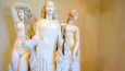 A marble sculpture of a woman holding a child, with another figure in the background.