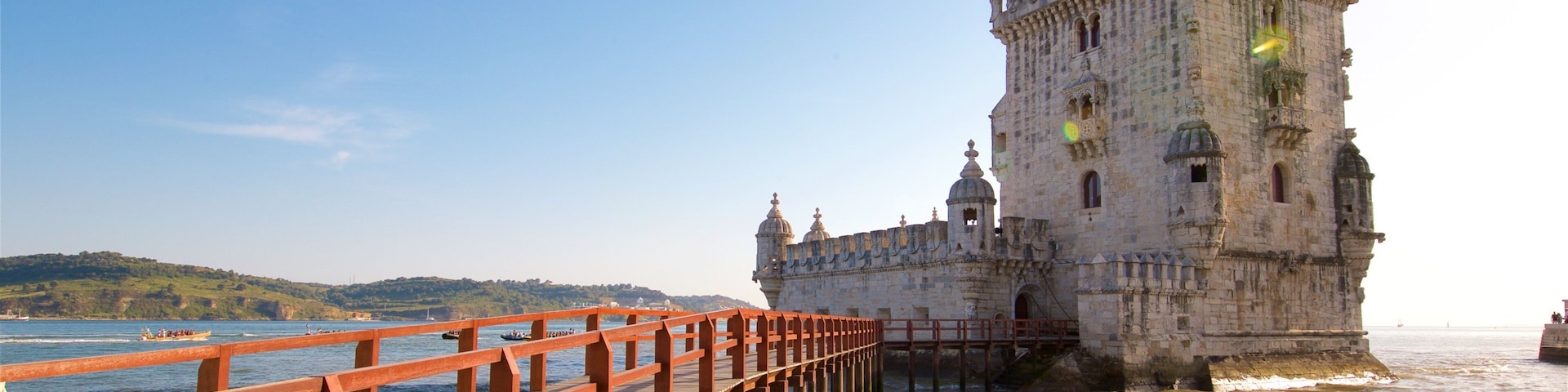 Belem Tower which includes general coastal views, a bridge and heritage architecture