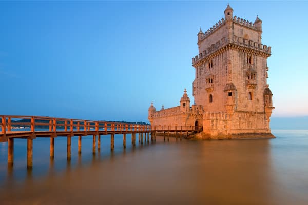 Belem Tower featuring a bridge, a sunset and heritage architecture