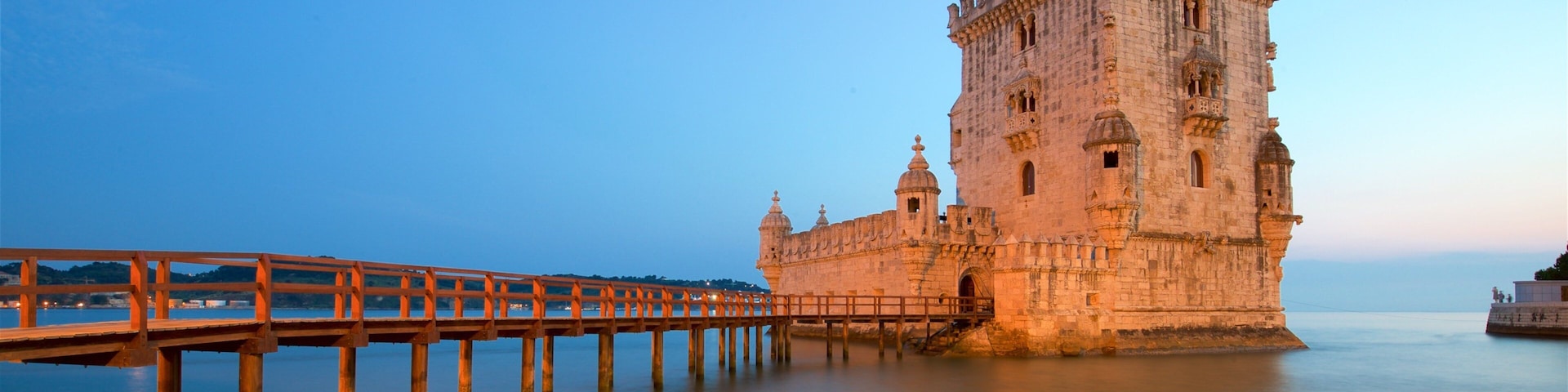 Torre de Belém caracterizando arquitetura de patrimônio, um lago ou charco e um pôr do sol