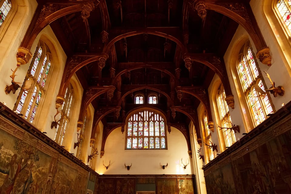 An ornate church interior with high vaulted ceilings, stained glass windows, and religious artwork.