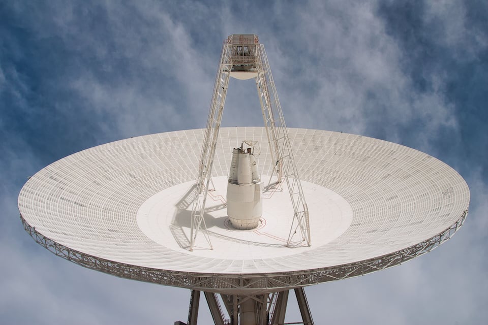 Une grande antenne parabolique dotée d’une structure centrale en forme de tour.