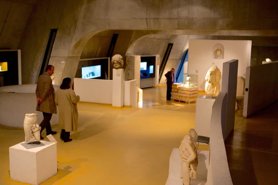An indoor museum with exhibits, including sculptures and informational displays.