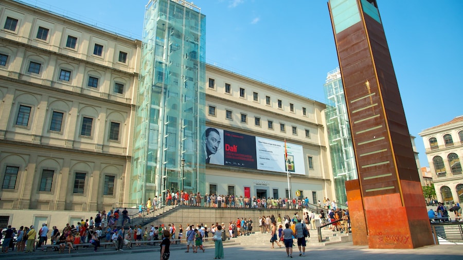 Museo Reina Sofia che include architettura moderna e piazza cosi come un grande gruppo di persone