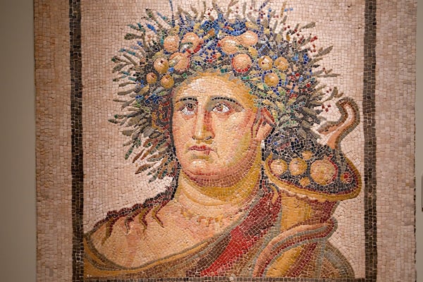 Ein Mosaik mit Blumenkrone und einem gewundenen Gewand.