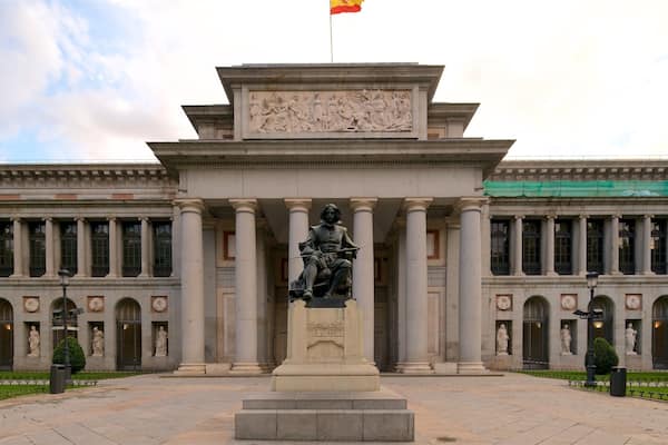 Ein neoklassizistisches Gebäude mit einer zentralen Statue, Säulen und einer Flagge.