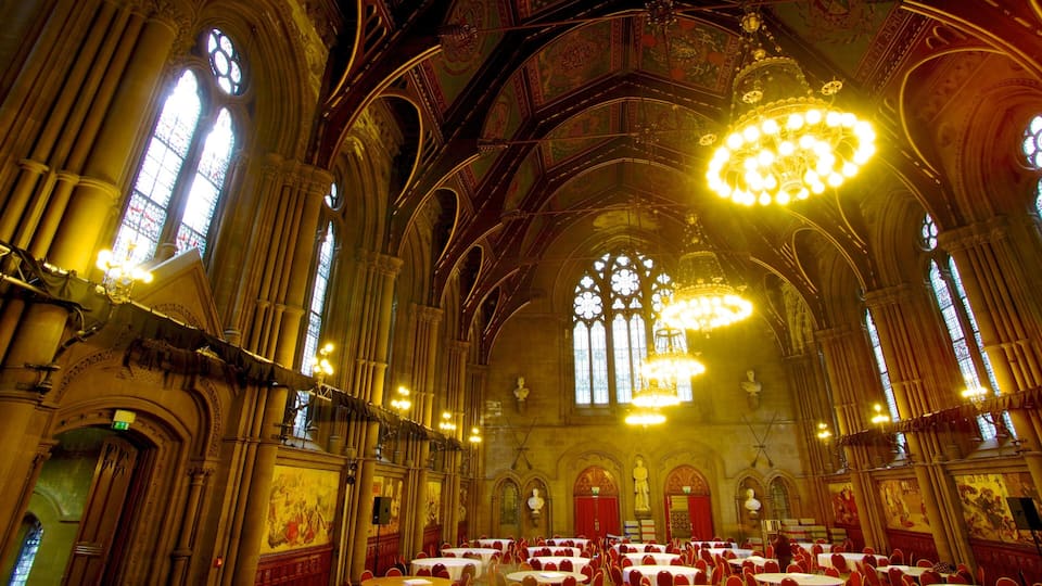 A grand cathedral interior with high vaulted ceilings, large stained glass windows, and ornate chandeliers.