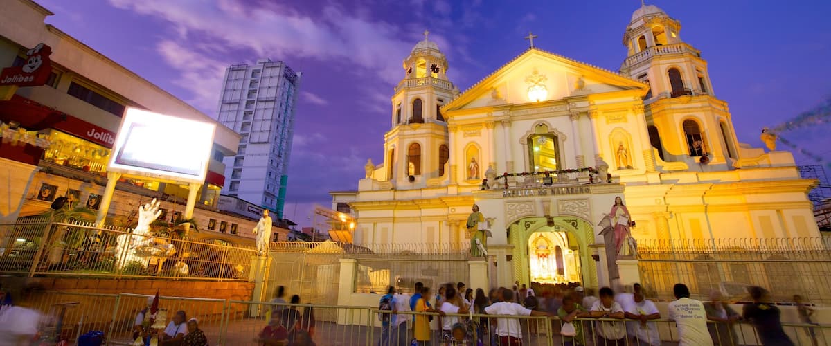 A historic cathedral with two bell towers and a large central dome, surrounded by a crowd of people.