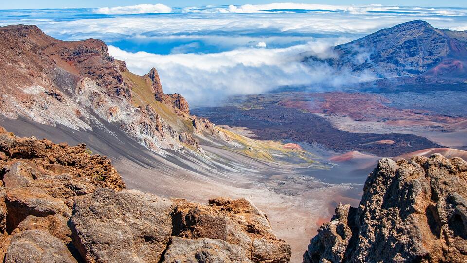 A rugged mountain landscape with rocky outcrops and a valley below.