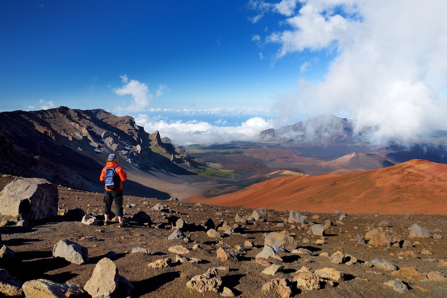 Tourist hiking in Haleakala volcano crater on the Sliding Sands trail. Beautiful view of the crater floor and the cinder cones below. Maui, Hawaii