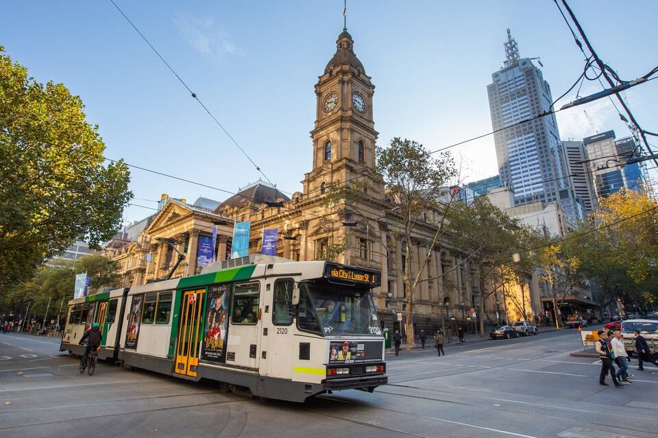 Un tram amb una torre del rellotge al fons.