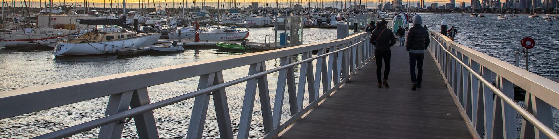 St Kilda Pier featuring a sunset and a bay or harbor as well as a couple