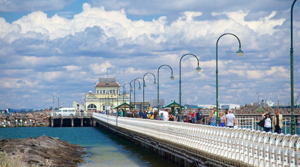 St Kilda Pier featuring heritage elements and a bay or harbor as well as a small group of people
