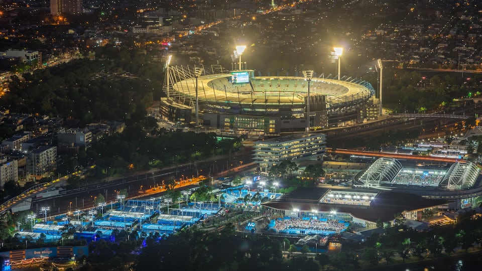 Un estadio grande rodeado de edificios urbanos y un río.