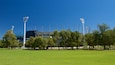 Un stade doté de projecteurs, d’une pelouse verdoyante et d’arbres.