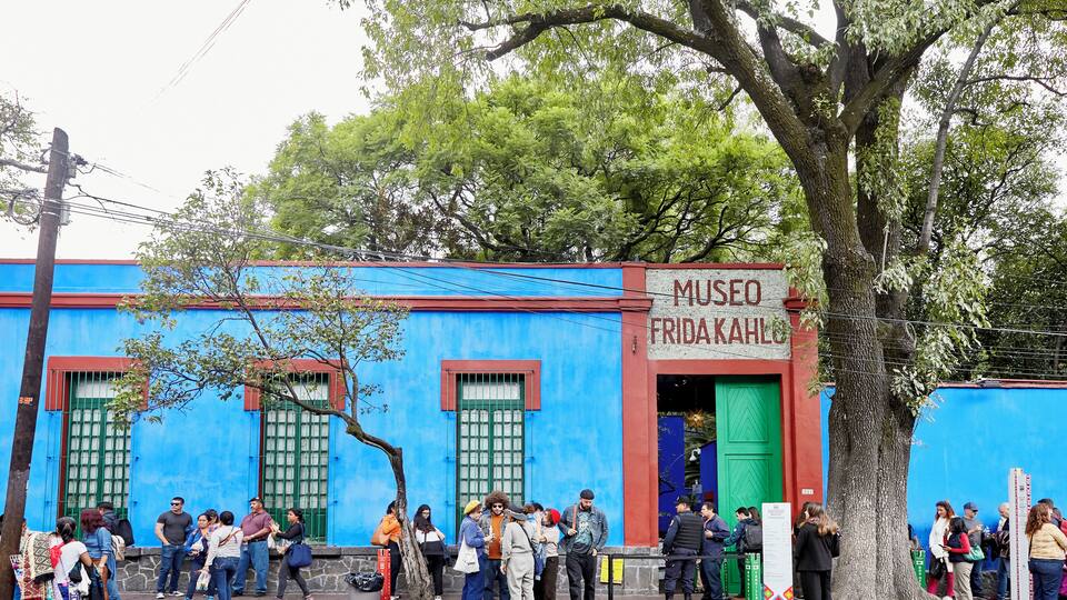 A blue building with a green door and windows, labeled "Museo Frida Kahlo".