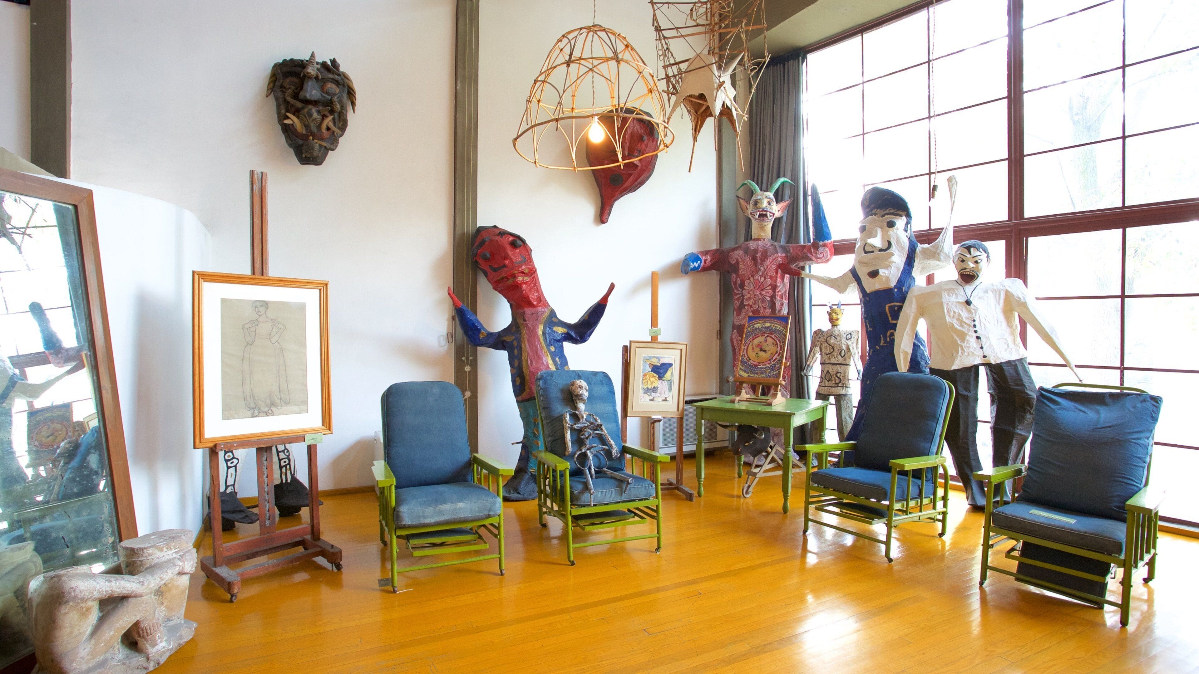 A room with various sculptures, paintings, and furniture.