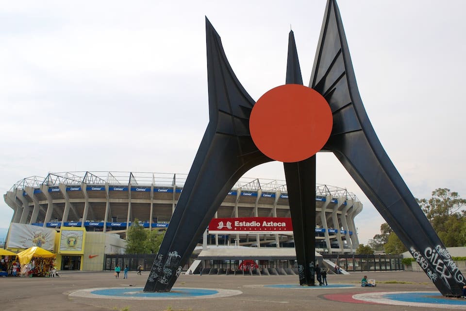 Un estadio grande con una escultura negra distintiva en primer plano.