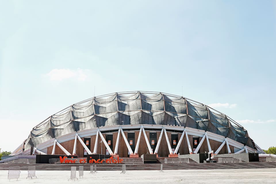 Ein großes, modernes Stadion mit markanter, geometrischer Dachkonstruktion.