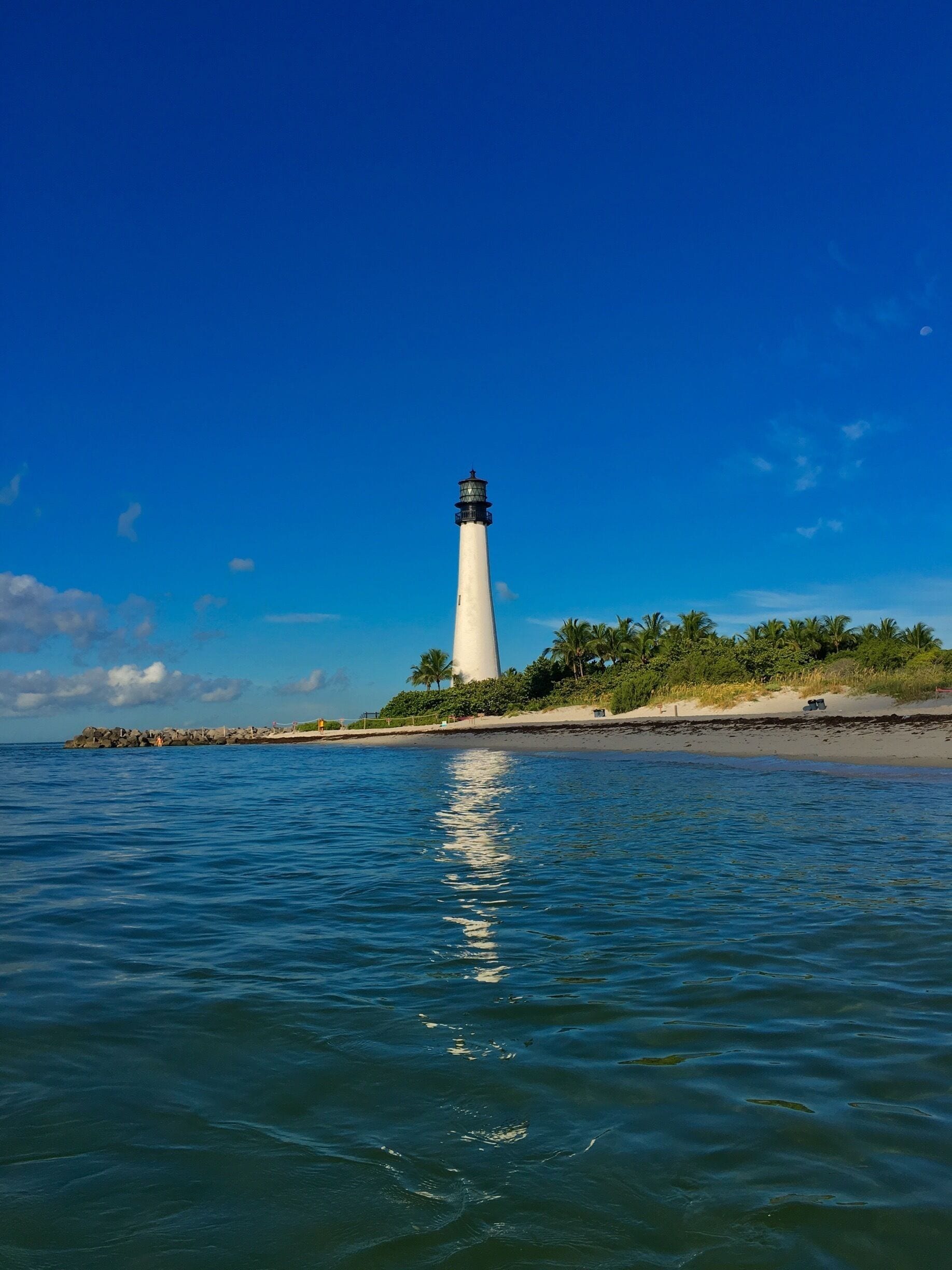 The Cape Florida Light is a lighthouse on Cape Florida at the south end of Key Biscayne in Miami-Dade County, Florida. Constructed in 1825, it guided mariners off the Florida Reef, which starts near Key Biscayne and extends southward a few miles offshore of the Florida Keys.  It was operated by staff, with interruptions, until 1878, when it was replaced by the Fowey Rocks lighthouse. The lighthouse was put back into use in 1978 by the U.S. Coast Guard to mark the Florida Channel, the deepest natural channel into Biscayne Bay. They decommissioned it in 1990.  Within the Bill Baggs Cape Florida State Park since 1966, the lighthouse was relit in 1996.  The beach is open to the public and is beautiful place to relax and spend the day by the ocean.