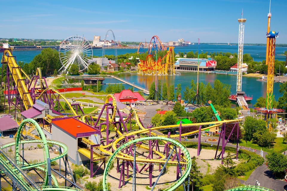 A theme park with roller coasters, a Ferris wheel, and a water body.