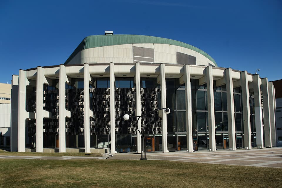A modern library with a curved roof and tall columns.