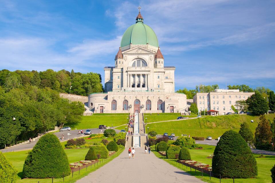 A large, historic building with a green dome and a central staircase leading to the entrance.