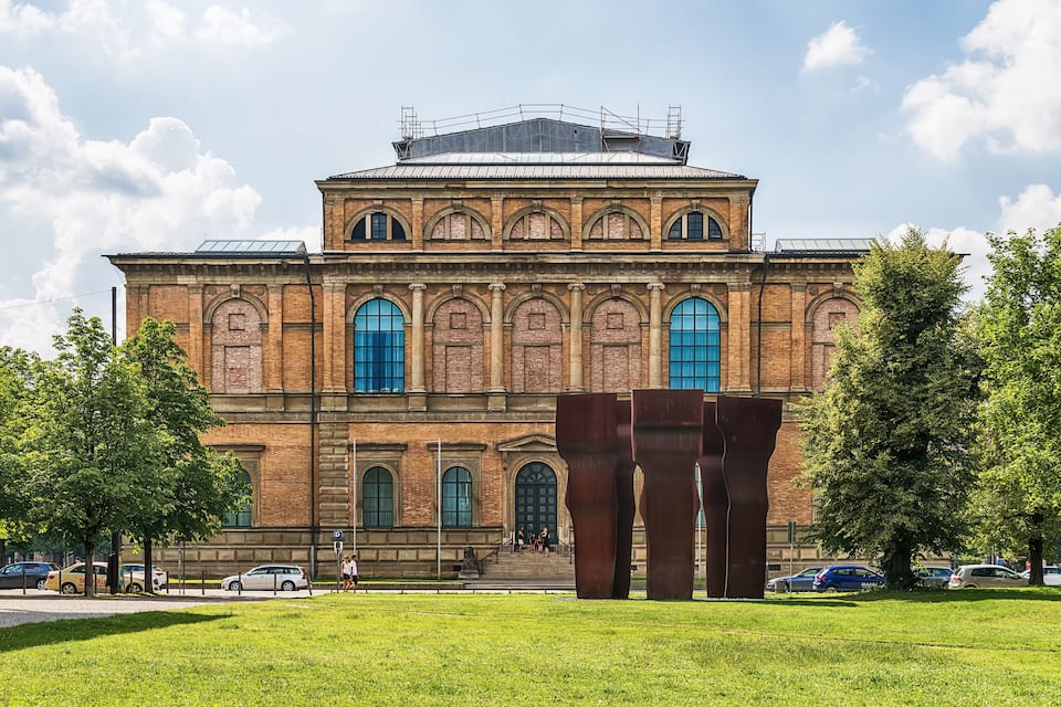 Un grand bâtiment en briques, doté de fenêtres en arc de cercle et surmonté d’un dôme.