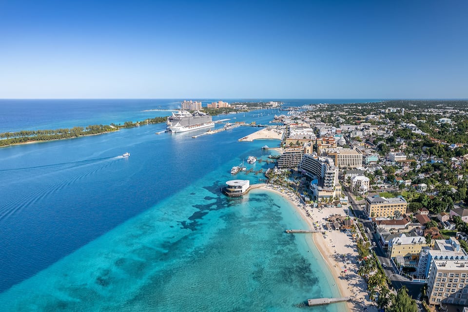 Uma cidade costeira com um porto, águas azul-claras e uma praia.
