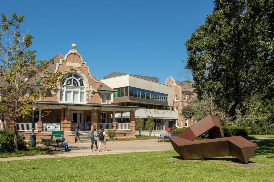 A historic building with a prominent clock tower and a modern extension.