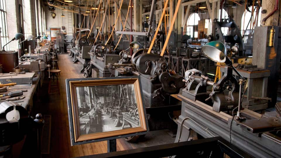 A workshop with various machinery and tools, including a framed historical photograph.
