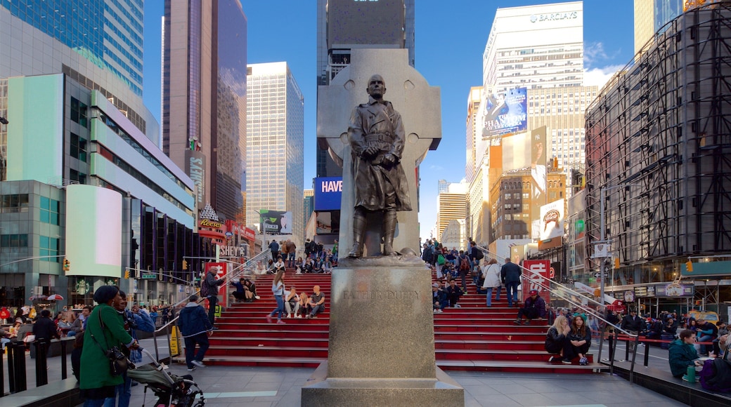 Times Square toont hoogbouw, een standbeeld of beeldhouwwerk en steden