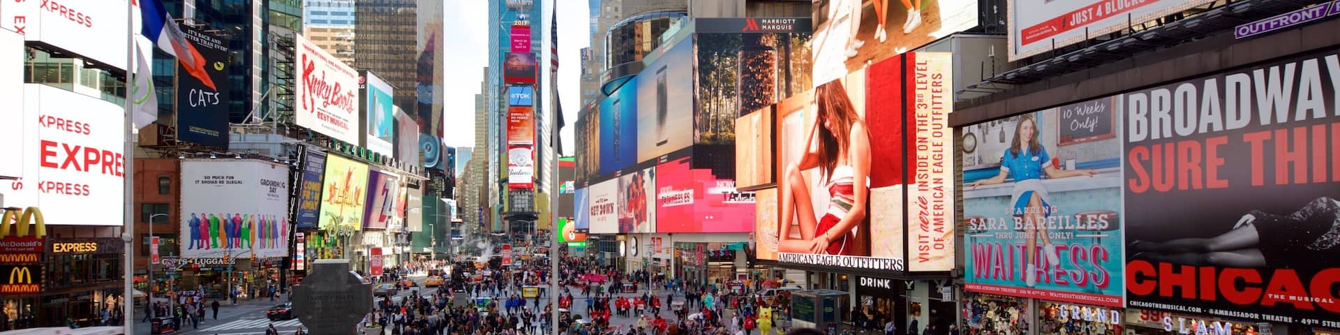 Times Square som viser skiltning, en skyskraber og en by
