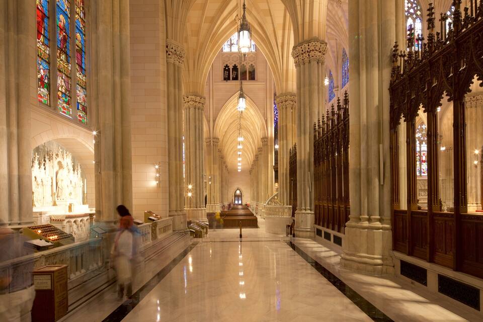 Ein Dominneres mit hohen Gewölbedecken, Buntglasfenstern und einem zentralen Altar.