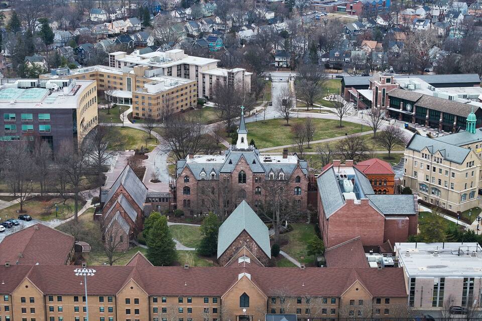 A university campus with historic buildings, green spaces, and a central clock tower.