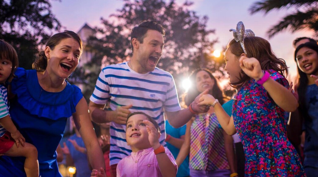 Disney Springs® showing a sunset as well as a family