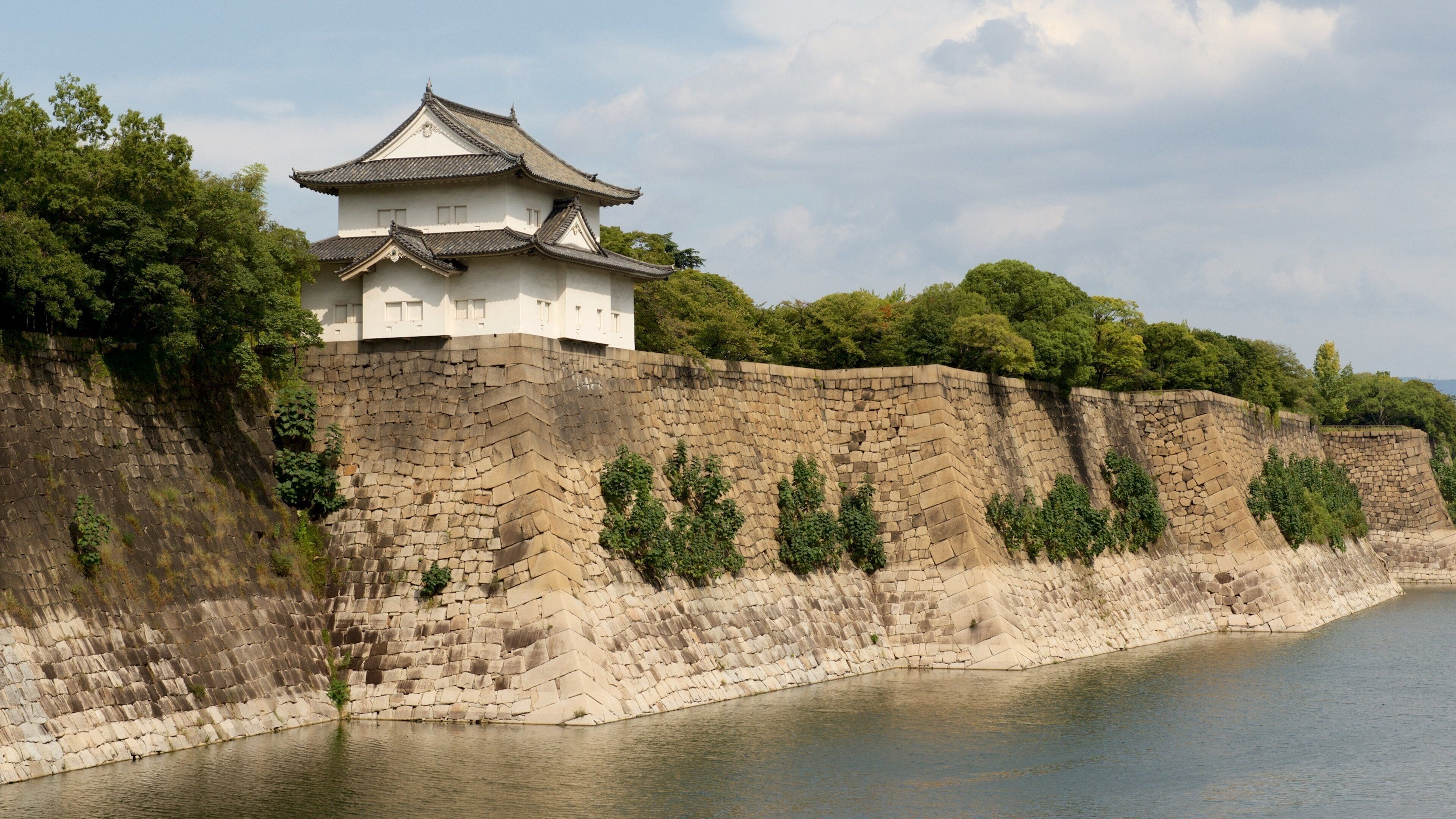 Osaka Castle featuring a lake or waterhole and heritage elements