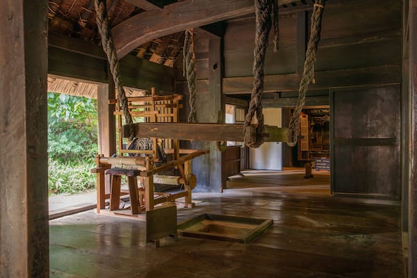 A traditional wooden interior with rope mechanisms and a thatched roof.