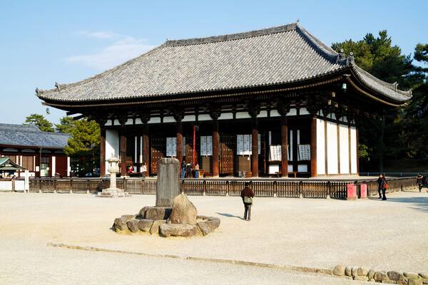 Un bâtiment japonais traditionnel, doté d’un toit recouvert de tuiles et de piliers en bois.