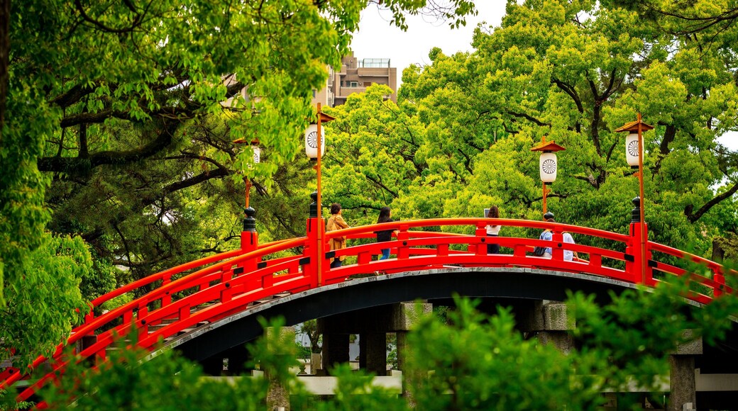 Sumiyoshi Taisha Shrine featuring a bridge as well as a small group of people