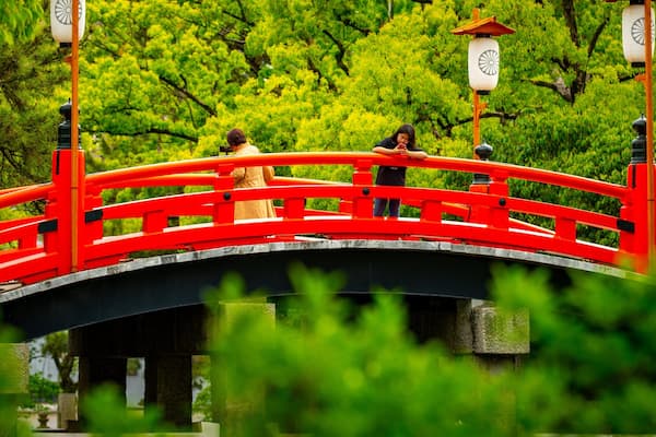 Sumiyoshi Taisha Shrine showing a bridge as well as an individual femail