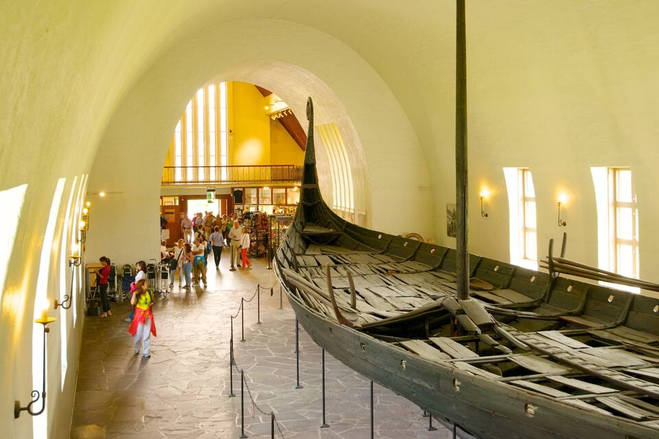 A large, arched interior with a Viking ship on display.