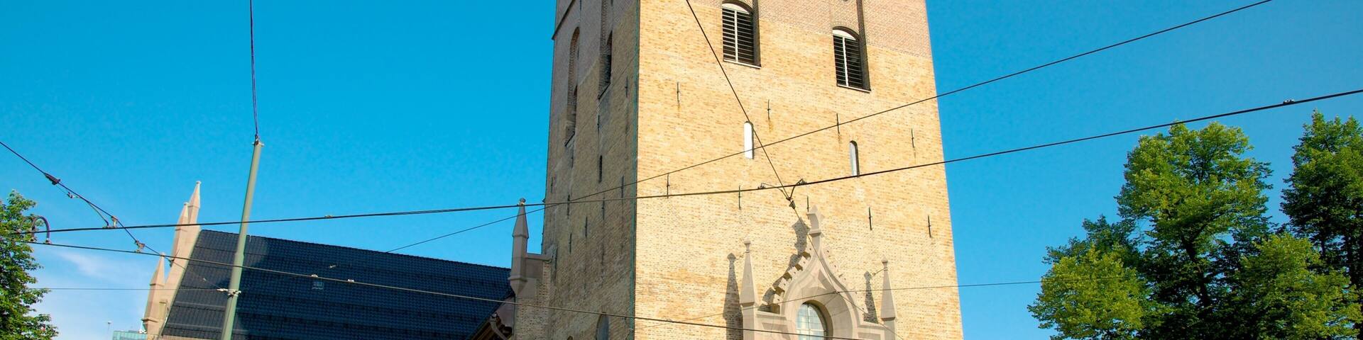 A historic church with a tall bell tower and a large arched entrance.
