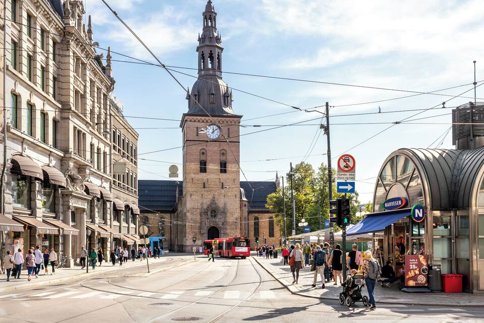 Edifici històric amb una torre de l'ajuntament, vies del tram i un tram en una plaça de la ciutat.