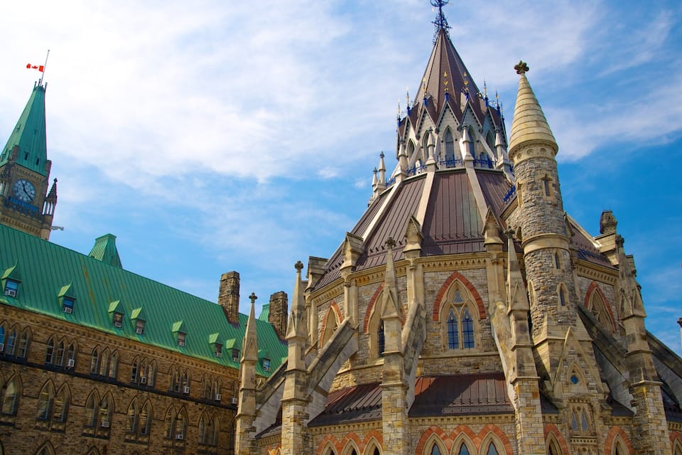 A historic building with a clock tower and a green roof.