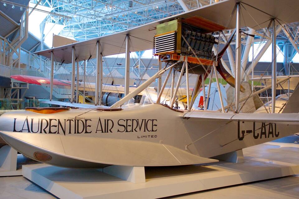 Un hidroavión antiguo con el texto "LAURENT AIR SERVICE LIMITED" en su costado, exhibido en el interior con una estructura metálica al fondo.