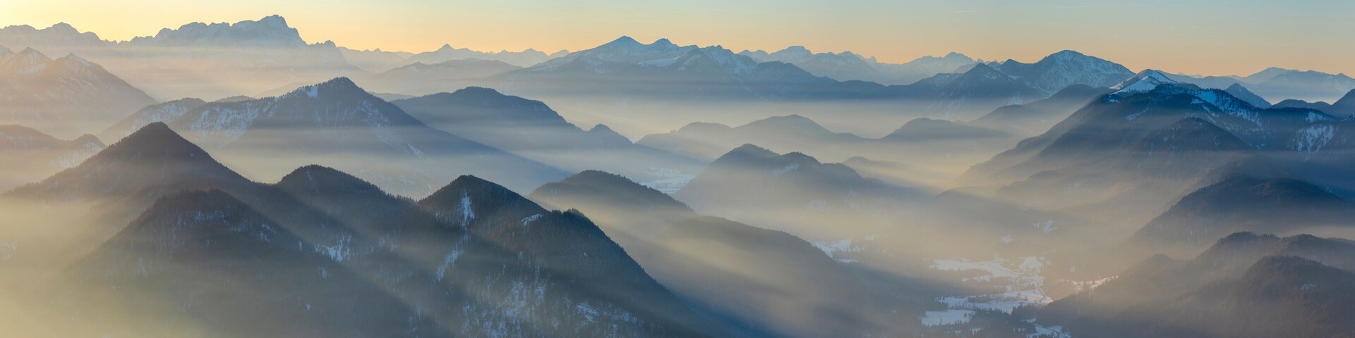 Cordillera con picos nevados y valles cubiertos de niebla.