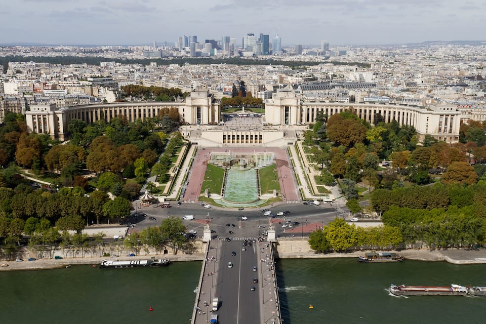 Un fiume con un ponte, un edificio con colonne e uno skyline sullo sfondo.