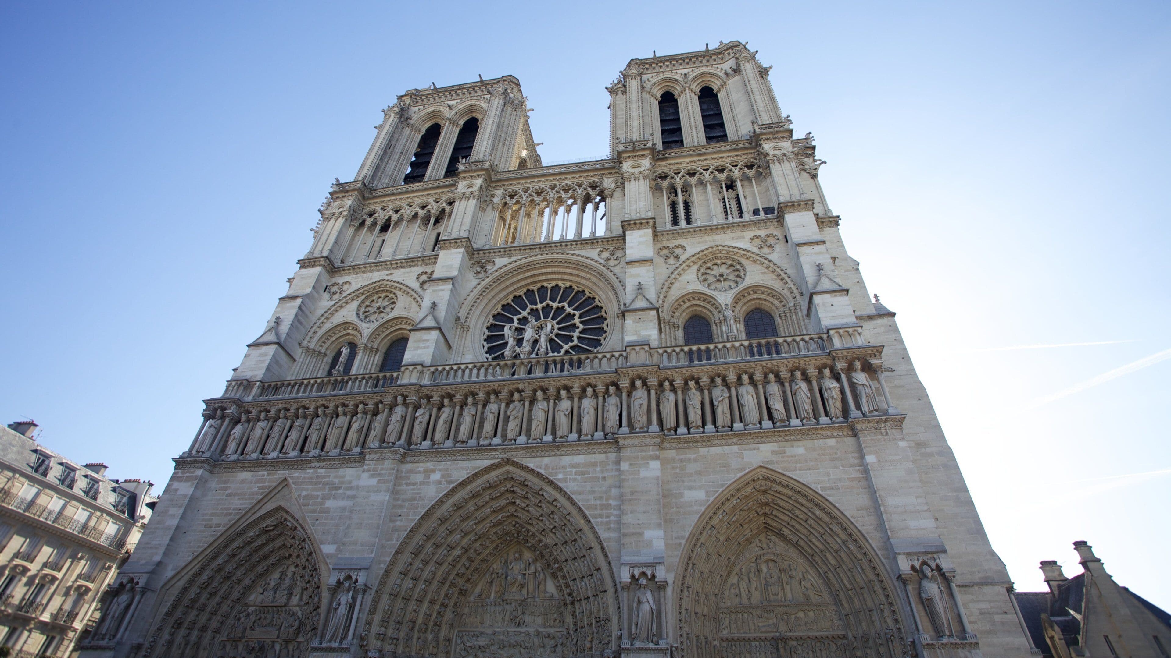 Stunning view of Notre-Dame Cathedral under a clear blue sky in Paris, showcasing its intricate architecture