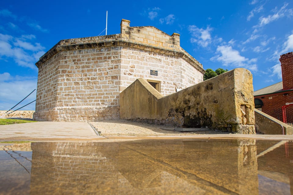 A stone fort with a flagpole, a flag, and a small window.